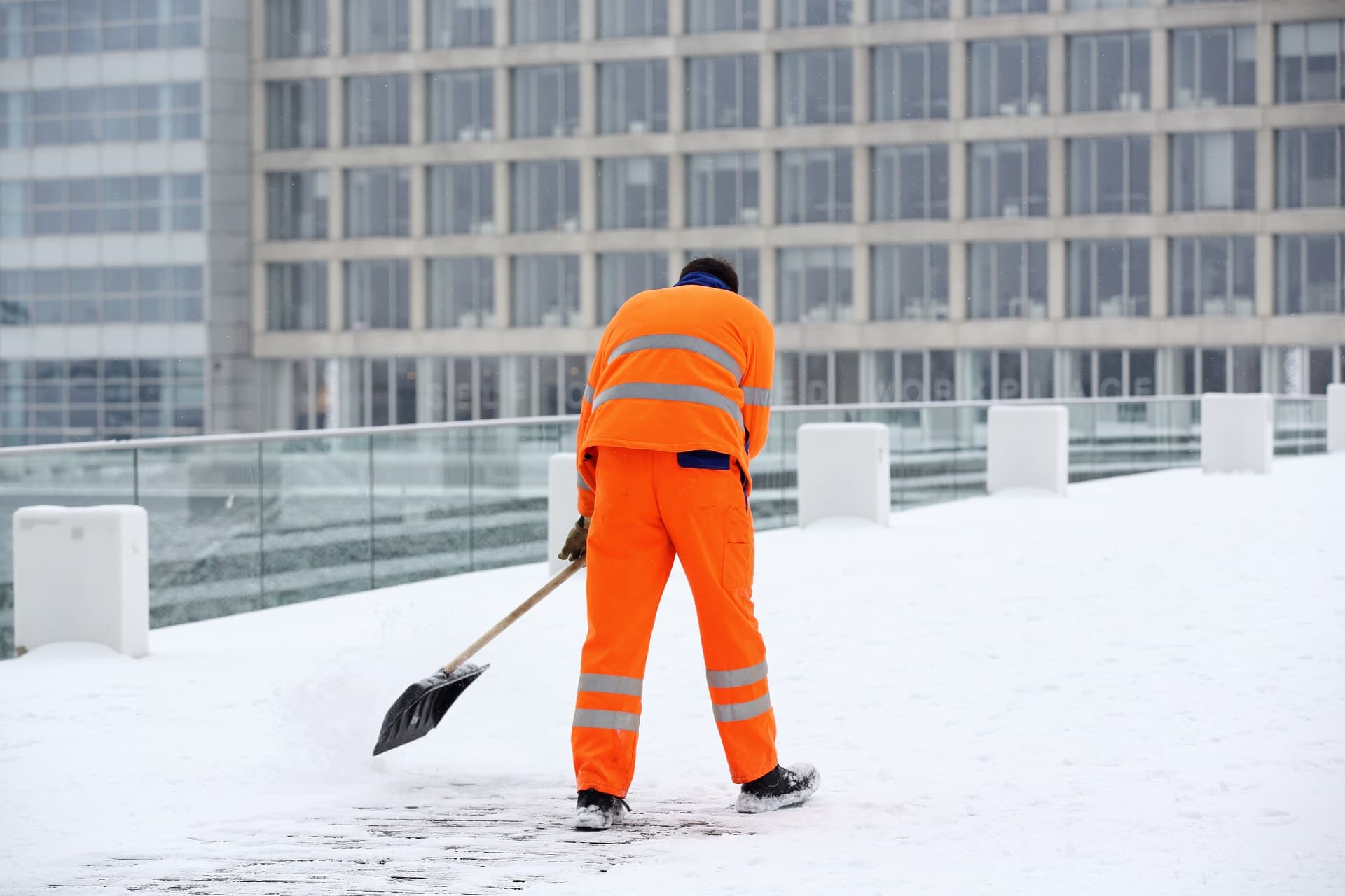 Mann vom Winterdienst beseitigt Schnee in Berlin.